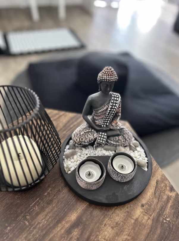 Meditationsaltar mit Buddha-Statue, Kerzen und Zen-Dekoration für eine achtsame Atmosphäre
