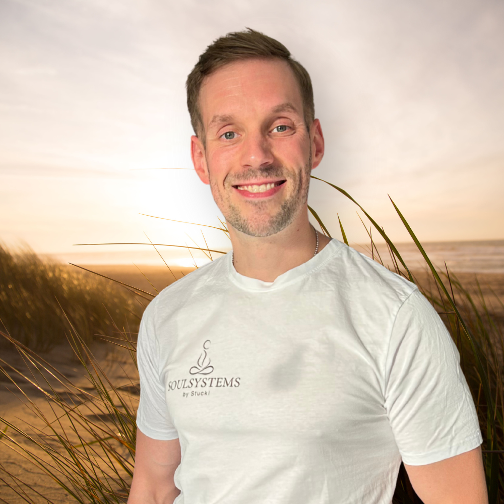 Stucki, Gründer von SoulSystems by Stucki, lächelnd am Strand bei Sonnenuntergang – dein Coach für innere Stärke & Balance
