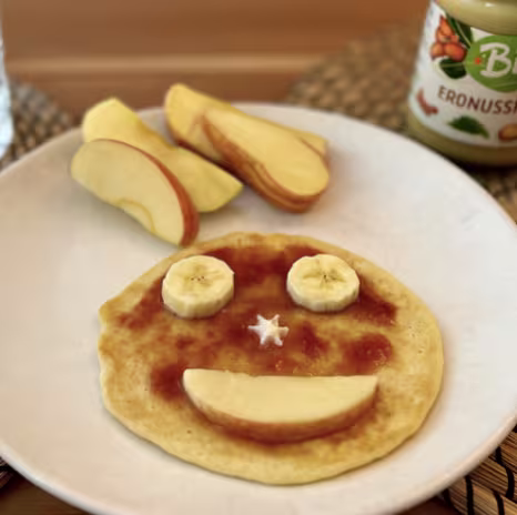 Gesundes Frühstück mit Smiley-Pancake aus Banane und Apfel – ein liebevoll angerichteter Start in den Tag